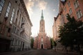 Panorama of the Saint Gertrude old church by a pedestrian cobblestone street of Riga at dusk in Summer. also called veca svetas