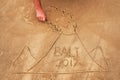 Picture on sand. Drawn volcano with text Bali inside.