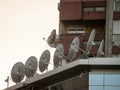 Satellite dishes and antennas on display at the top of a business building at sunset. These are used for communications Royalty Free Stock Photo