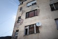 Satellite dish and and TV UHF antennas on display at the windows of a decaying facade of a residential building. These are used Royalty Free Stock Photo