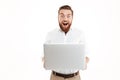 Happy young bearded man using laptop. Royalty Free Stock Photo