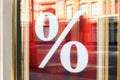 Picture of shop window display with percent sign Sale on red poster. Store discount sign in rich luxe vintage style. Seasonal dis