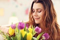 Attractive woman arranging tulips flowers in vase Royalty Free Stock Photo