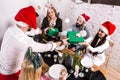 Picture showing group of friends celebrating Christmas at home and giving presents to each other Royalty Free Stock Photo