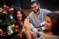 Group of friends with presents celebrating Christmas at home Royalty Free Stock Photo