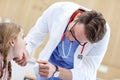 Little girl in clinic having a checkup with laryngologist