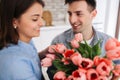 Picture showing man giving flowers to a woman at home. Romantic concept. Woman`s day