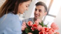 Picture showing man giving flowers to a woman at home. Romantic concept. Woman`s day