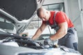 Picture showing muscular car service worker repairing vehicle Royalty Free Stock Photo