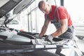 Picture showing muscular car service worker repairing vehicle Royalty Free Stock Photo