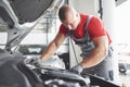 Picture showing muscular car service worker repairing vehicle Royalty Free Stock Photo