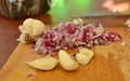 Peeled garlic and choped red onion on a rustic wooden board Royalty Free Stock Photo