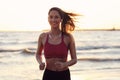 Woman running alone at beautiful dusk on the beach