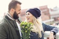 Picture showing young couple with flowers dating in the city Royalty Free Stock Photo