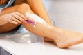 Young woman shaving legs in bathroom in the morning Royalty Free Stock Photo