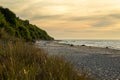 Beach on a warm summer day at the golden hour and trees on the embankment. Royalty Free Stock Photo