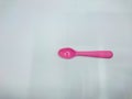 The picture shows a pink spoon plastic on a white background.