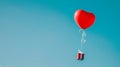 Red heart-shaped balloon with gift box on blue sky background. Royalty Free Stock Photo