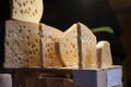 Slices of French and Swiss emmental cheese, wrapped, with their iconic hole bubbles, on display for sale.