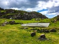 Small rowing boat on green grassy rocky ground