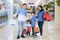 Smiling Muslim family hold shopping bags in mall