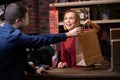 Picture of smiling seller woman giving paper bag to male