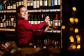 Picture of smiling woman with bottle in her hands in wine shop