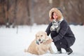 Picture of smiling woman squatting next to labrador with toy in teeth in winter park Royalty Free Stock Photo