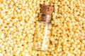 Picture with soft focus of tiny corked glass jar with millet on background from millet, top view. Concept of healthy nutrition, Royalty Free Stock Photo