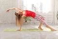 Picture of sporty beautiful blond young woman in sportswear working out in hall, doing Variation of Bridge Pose. Royalty Free Stock Photo