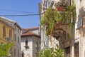 Picture on a stone balcony on a historic facade with flowers and green plants