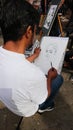 Male artist drawing portraits in public