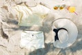 Picture of summer stuf lying on sand on the sun. There are yellow shorts, T-shirt, hat, sunglasses, cocktail