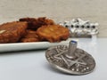 A plate full of Hannukah potato latkes fritters with a silver dreidel on a white table with a silver chanukiah in the background Royalty Free Stock Photo