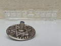 A silver dreidel on a white table with a glass chanukiah in the background Royalty Free Stock Photo