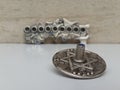 A silver dreidel on a white table with a silver chanukiah in the background Royalty Free Stock Photo