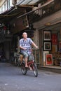 Hanoi, Viet Nam - July 05,2019: An old man is riding bicycle in the street