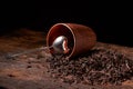 Picture of the tea strainer with dried tea leaves and sticks of cinnamon isolated on dark wooden background