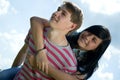 Picture of teenage boy and girl embracing over sky