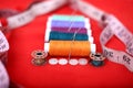 Picture of threads, needles, bobbin, measure tape and button