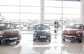 Picture of three nice Fiat cars standing inside trading salon with glass walls. It is bright inside and outsode as well