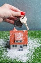Picture of toy house with falling snow and hands with key Royalty Free Stock Photo