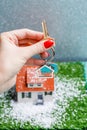 Picture of toy house with falling snow and hands with key Royalty Free Stock Photo