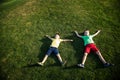 Picture of two brother having fun in the park  two cheerful children laying down on green grass  little boy and his friend playing Royalty Free Stock Photo