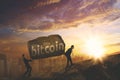 Two businessmen carrying bitcoin word on the cliff