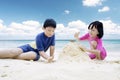 Two children making sand castle on beach Royalty Free Stock Photo