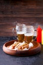 Picture of two mugs of beer and hot dogs on wooden tray Royalty Free Stock Photo