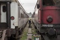 Rail worker manoevring between two passenger trains on the platforms of Belgrade train station, making them ready for departure Royalty Free Stock Photo