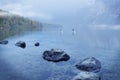 Two women kayaking in a foggy lake