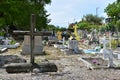 Picture of an unknown colored cemetery with a beautiful wooden cross in the foreground.